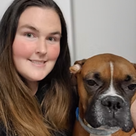 The Pawsitively Southern groomer posing with a boxer dog.